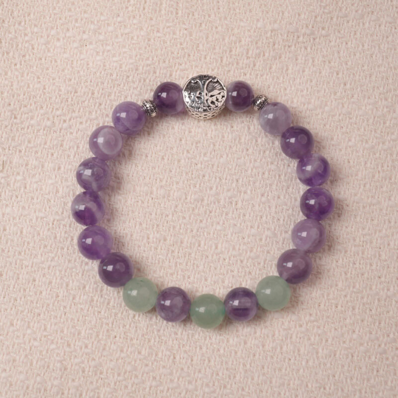 Amethyst and prehnite bracelet with a silver accent bead, photographed under soft daylight to highlight the calming purple and gentle green tones.