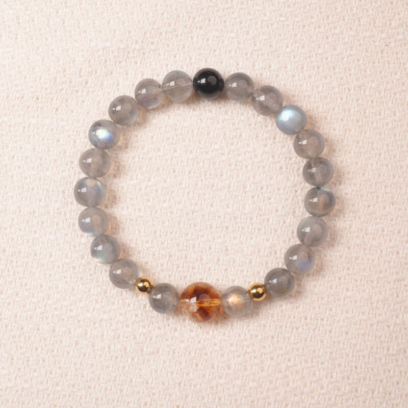 Moonstone bracelet with gentle blue sheen and golden accent bead, symbolizing calmness and intuition.