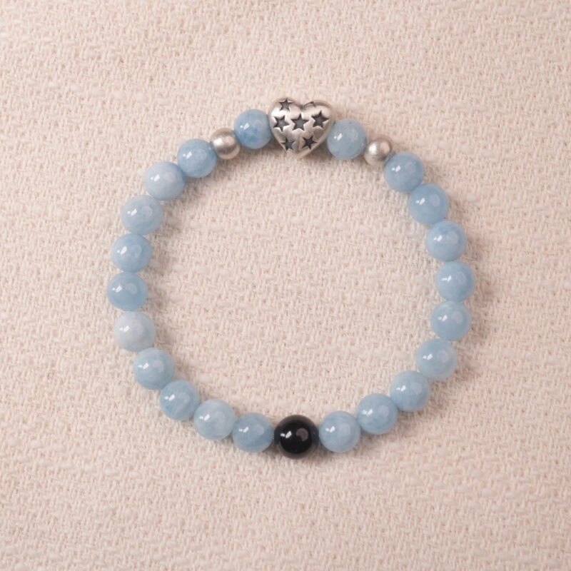 Aquamarine bracelet with silver heart charm and black accent bead, symbolizing calmness and clear communication.