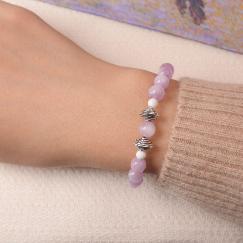 Model wearing kunzite and moonstone bracelet with silver accent beads, radiating gentle feminine energy.