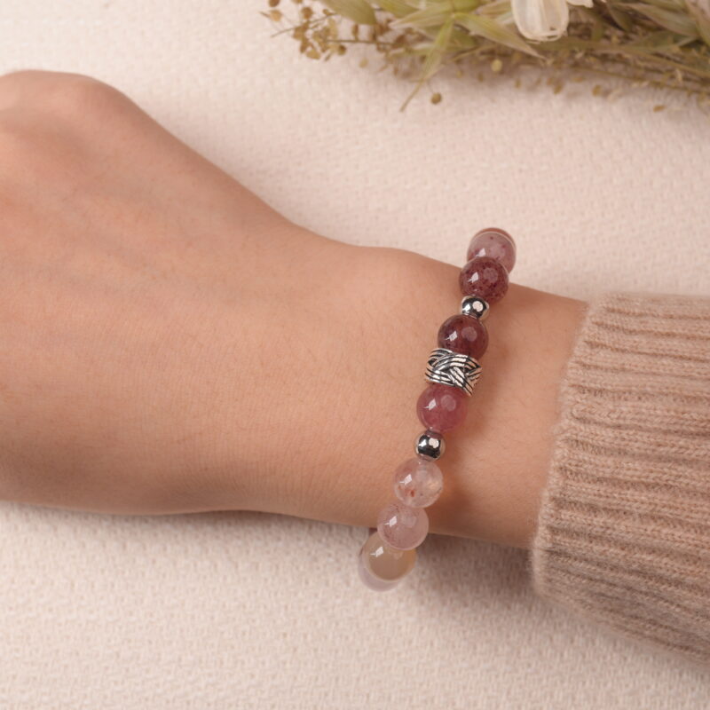 Model wearing strawberry quartz and amethyst bracelet, showcasing warm pink hues and elegant shine.