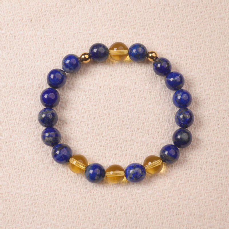 A close-up of a Lapis Lazuli and Citrine bracelet, featuring polished deep blue Lapis Lazuli beads and bright yellow Citrine beads. The bracelet is accented with gold spacer beads for a luxurious touch.
