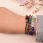 Good luck gemstone bracelet stack on wrist, showcasing mixed natural crystal beads in lively colors.
