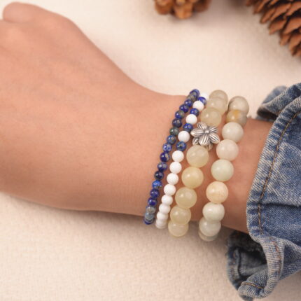 A calming gemstone bracelet stack featuring blue sodalite, white jade, and soft moonstone, worn on the wrist.