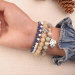 Side view of a calm-intention crystal bracelet stack showing blue and neutral-toned gemstones.