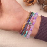 Calm crystal bracelet set worn on wrist with soothing purple, teal and green gemstones
