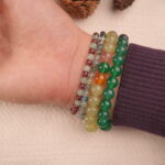 Good luck gemstone bracelet stack worn on wrist, featuring a mix of vibrant and earthy beads