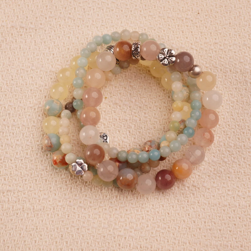 Flatlay of calm intention bracelet stack featuring moonstone, amazonite and jade beads