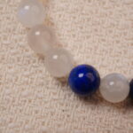 Close-up of the Moonstone and Lapis Lazuli beads, showcasing their smooth texture and vibrant colors, with a silver accent bead adding a touch of sophistication.