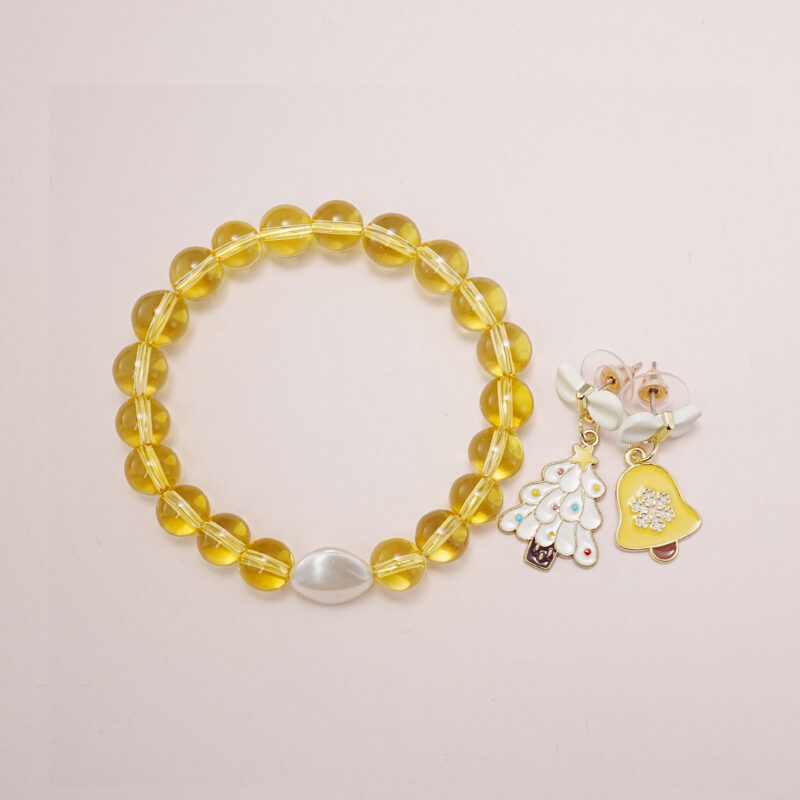 A bright yellow quartz bead bracelet with a white pearl centerpiece, paired with yellow bell and Christmas tree bow earrings.