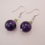 Close-up of the purple amethyst earrings, featuring simple yet elegant design with silver hooks.