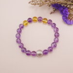 The Amethyst and Citrine bracelet placed on a soft background, emphasizing the vibrant colors and the harmonious design. Perfect for enhancing a calm and peaceful atmosphere.