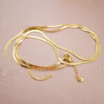 Long chain necklace displayed on a soft pink background