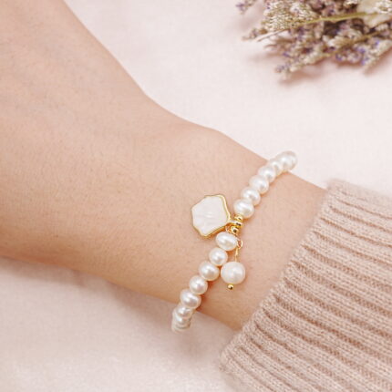 White pearl bracelet with charm worn on wrist for a delicate feminine look