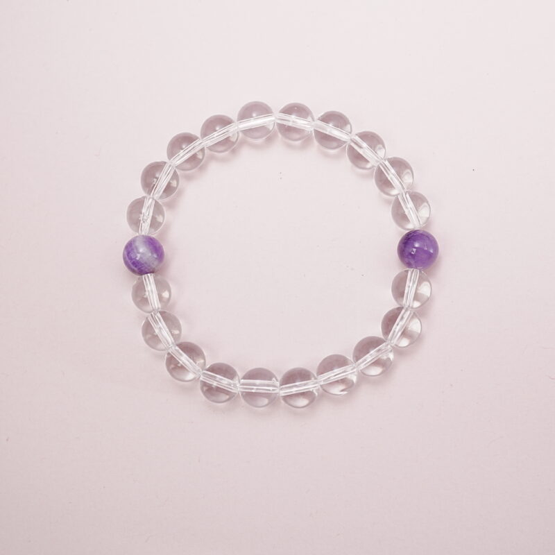 Clear quartz bracelet with two amethyst accent beads – main product image.