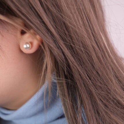 Model wearing classic pearl stud earrings