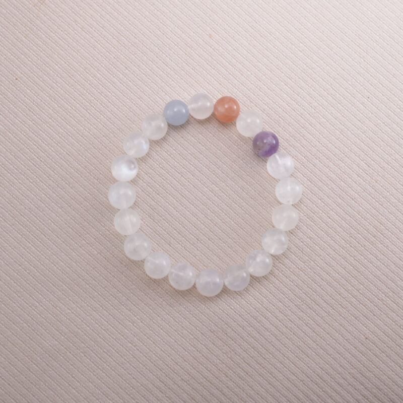 White Moonstone beaded bracelet with pastel accent gemstones on a soft beige background.