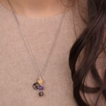 Model wearing Sagittarius zodiac necklace with yellow chalcedony, amethyst, and smoky quartz.