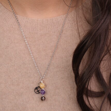 Model wearing Sagittarius zodiac necklace with yellow chalcedony, amethyst, and smoky quartz.