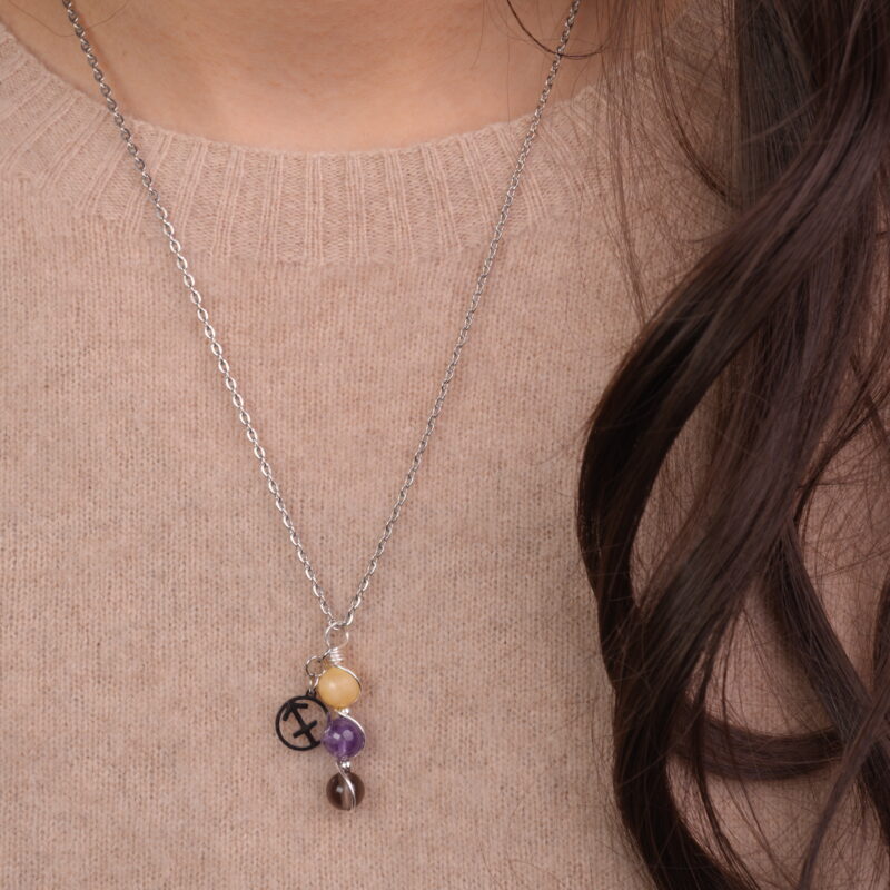 Model wearing Sagittarius zodiac necklace with yellow chalcedony, amethyst, and smoky quartz.