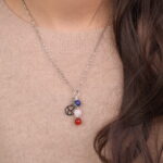 Taurus zodiac necklace with lapis lazuli, clear quartz, and red agate gemstones.