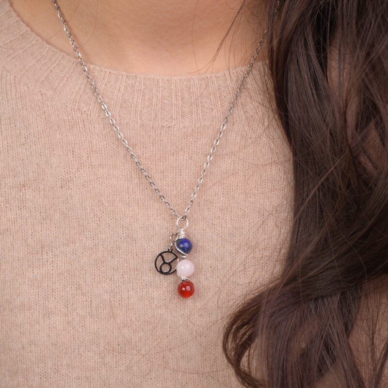 Taurus zodiac necklace with lapis lazuli, clear quartz, and red agate gemstones.