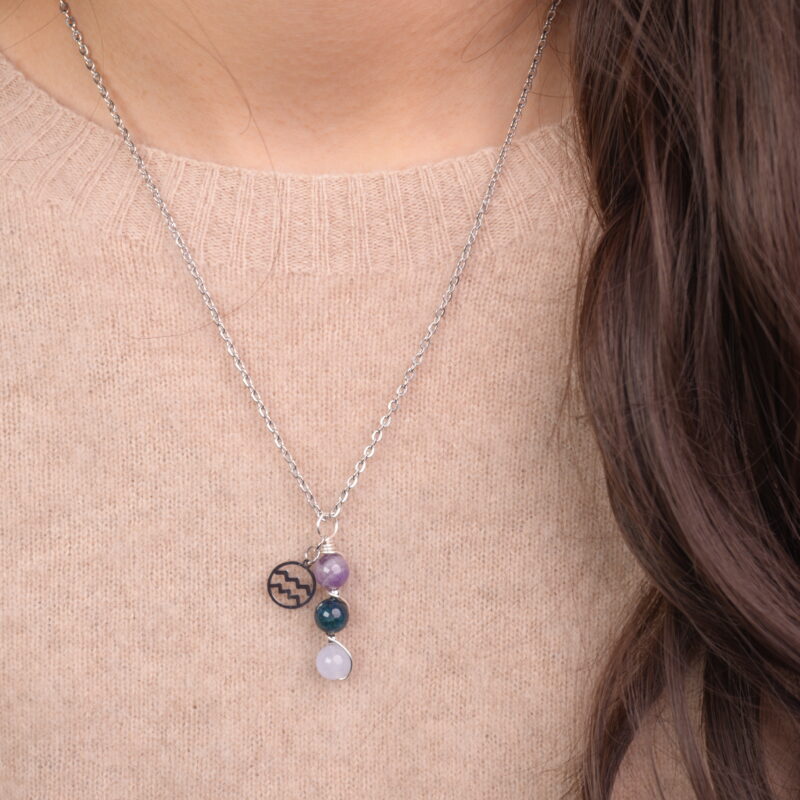 Model wearing Aquarius zodiac necklace with amethyst, blue apatite, and aquamarine.