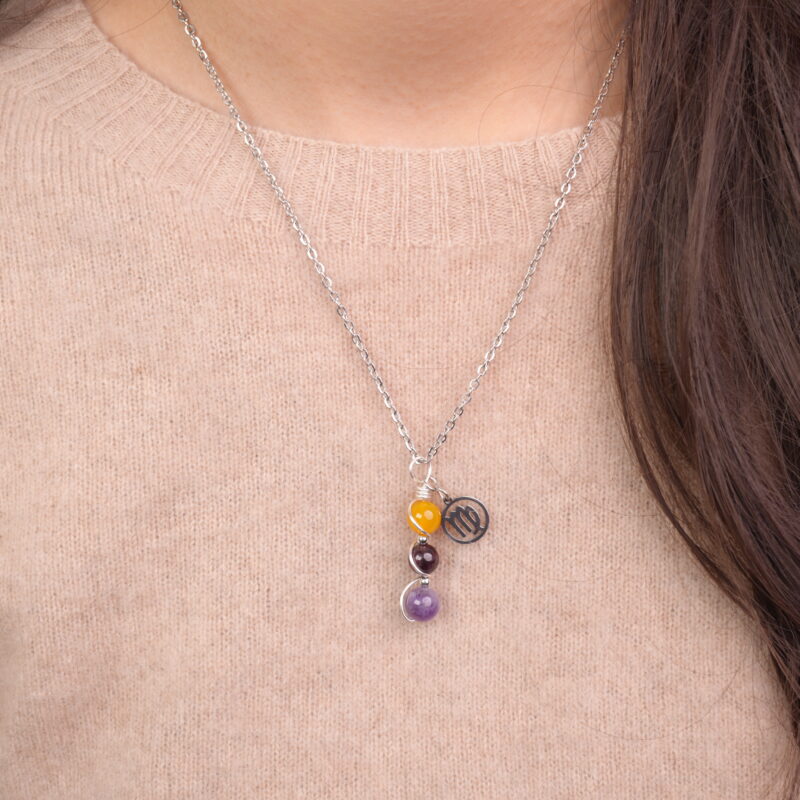 Model wearing Virgo zodiac necklace with yellow agate, garnet, and amethyst.