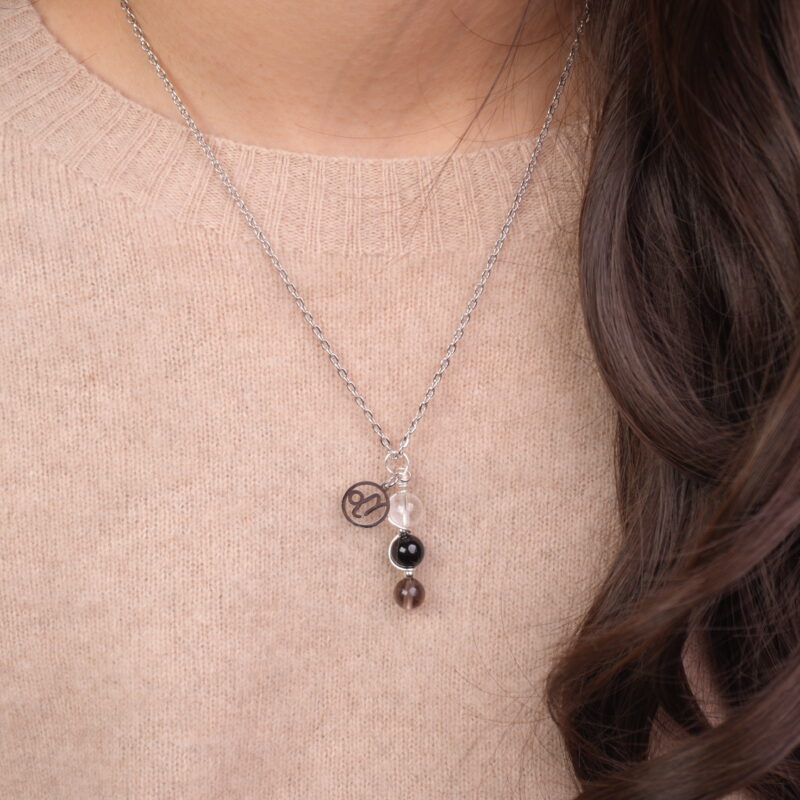 Model wearing Capricorn zodiac necklace with clear quartz, obsidian, and smoky quartz.