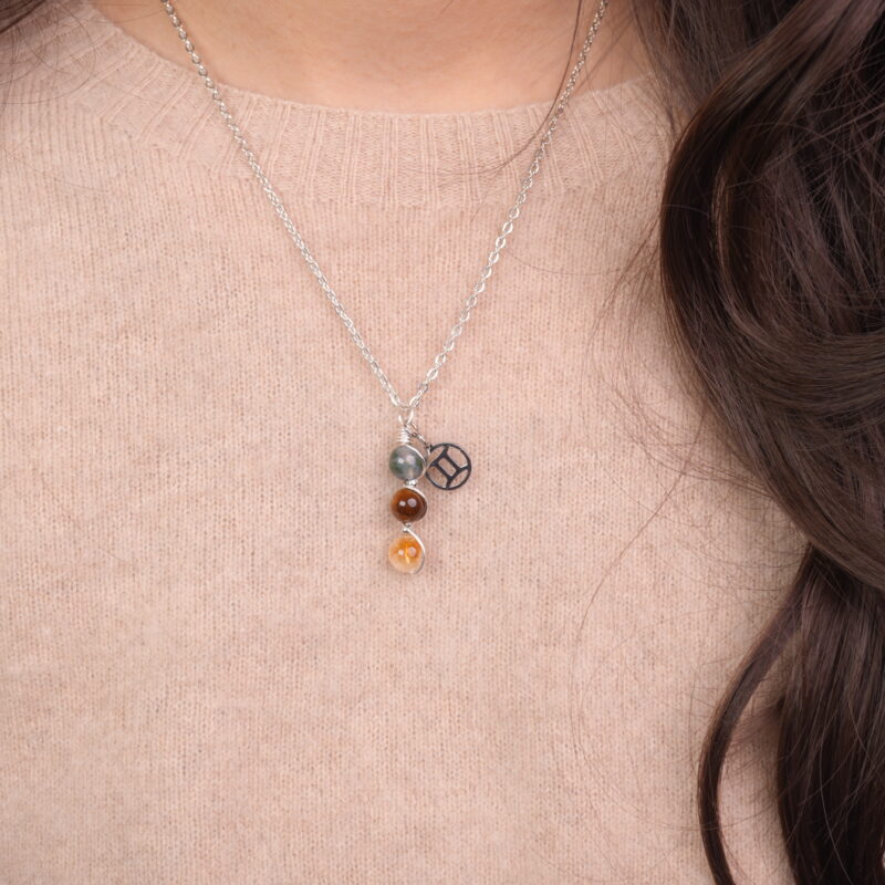 Model wearing Gemini zodiac necklace with moss agate, tiger eye, and citrine.