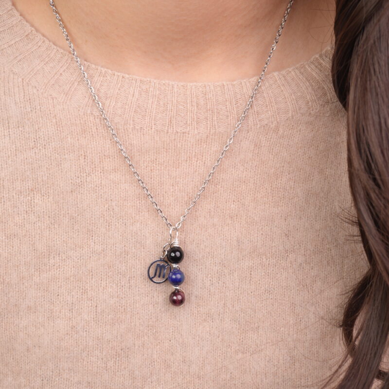 Model wearing Scorpio zodiac necklace with obsidian, lapis lazuli, and garnet.