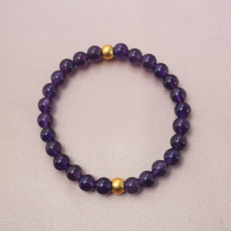 Deep purple amethyst bracelet with golden beads, symbolizing calm energy and inner wisdom.