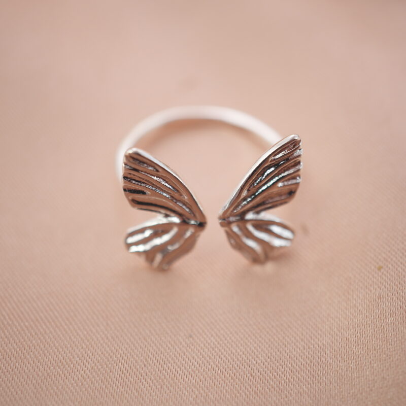 Silver butterfly wing adjustable ring featuring an open design symbolizing freedom and transformation.