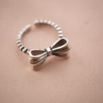 Vintage bow adjustable silver ring with a delicate ribbon design symbolizing grace and femininity.