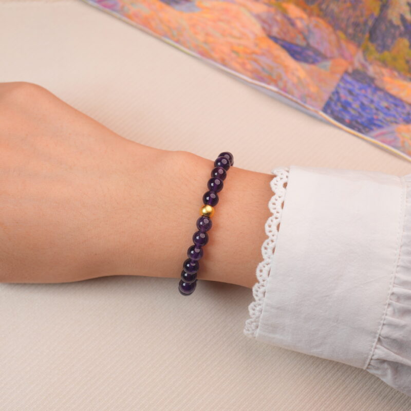 Model wearing the deep amethyst bracelet with golden accents, showing a graceful and elegant look.