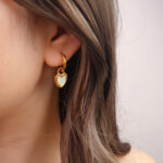 White heart enamel hoop earring worn on the ear