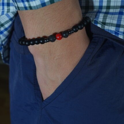 Men wearing matte black obsidian and red turquoise bracelet on wrist with casual outfit