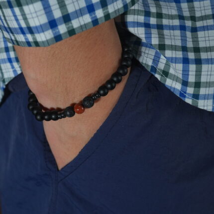 Man wearing obsidian and cinnabar bracelet on wrist, shown in a casual everyday setting