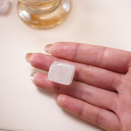 Clear quartz crystal cube in hand, representing purification, focus, and amplified positive energy