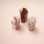 Set of three crystal points – red jasper, tiger’s eye, and tourmalinated quartz – representing grounding and balance.