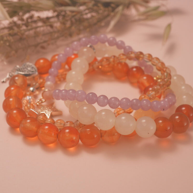 Warm-toned vitality bracelet stack displayed in gentle sunlight, symbolizing life energy and renewal.
