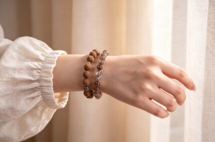 Two juniper botanical bead and black gold sunstone bracelets stacked on a woman’s wrist