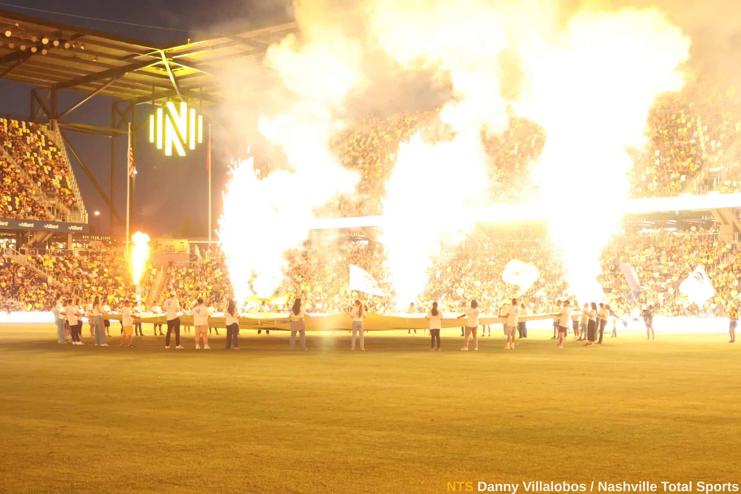 Espectáculo pirotécnico en GEODIS Park con pancarta extendida y afición de Nashville SC de fondo