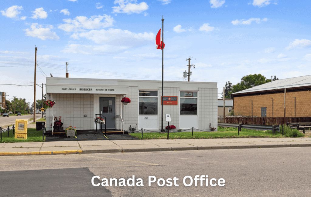 Post office building in Canada with flag and flowers, representing community and postal services.