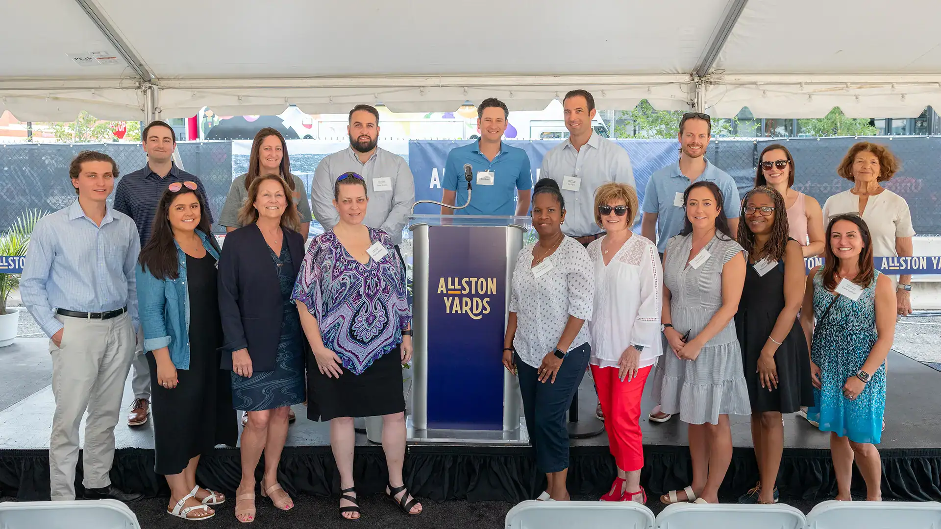 Group of diverse professionals at Allston Yards groundbreaking event outdoors.