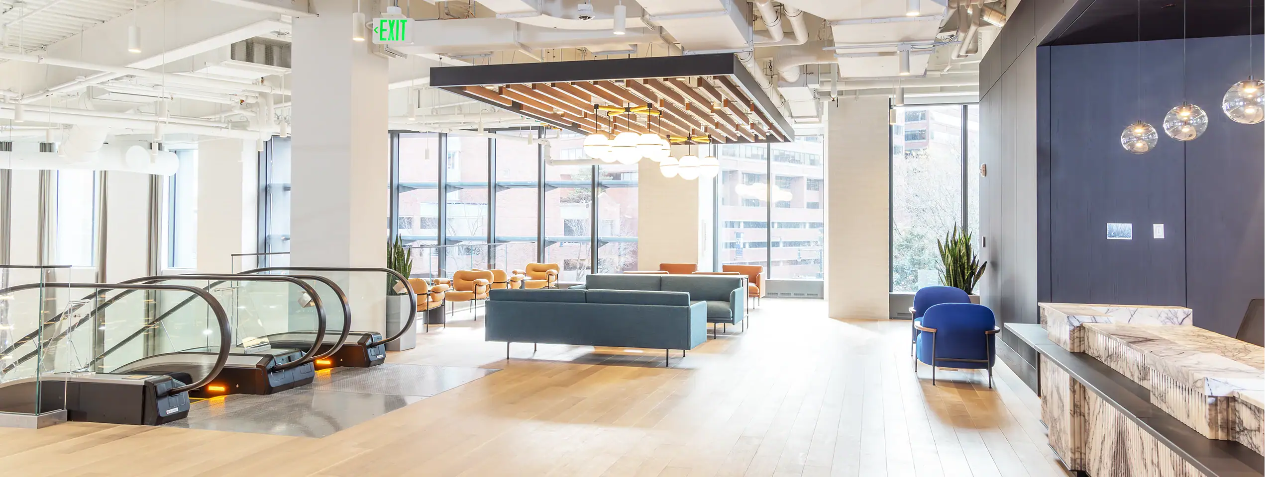 Modern, bright office lobby with seating and large windows.