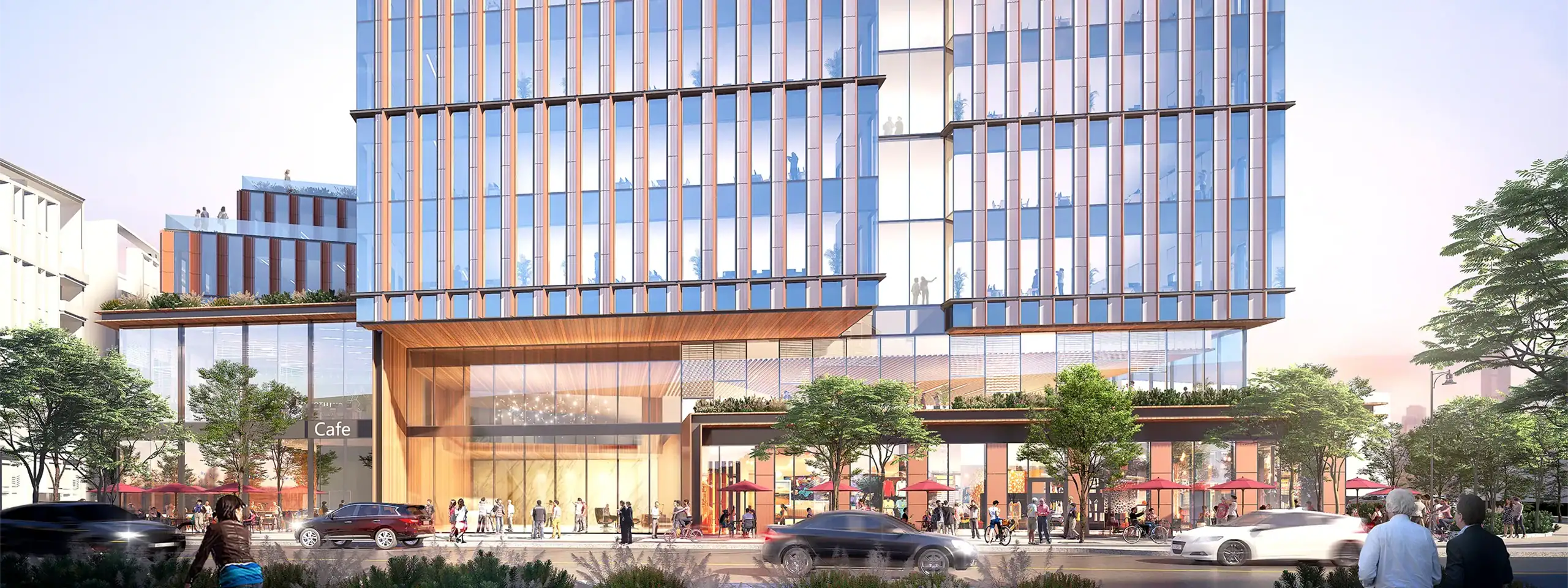 Modern multi-story building with glass facade and retail shops at street level.