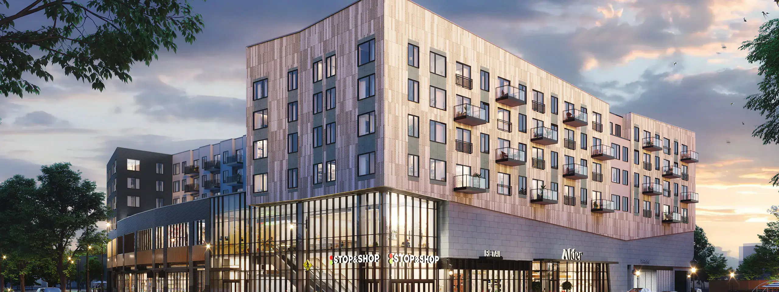 Modern multi-story residential building with balconies and retail space at street level.