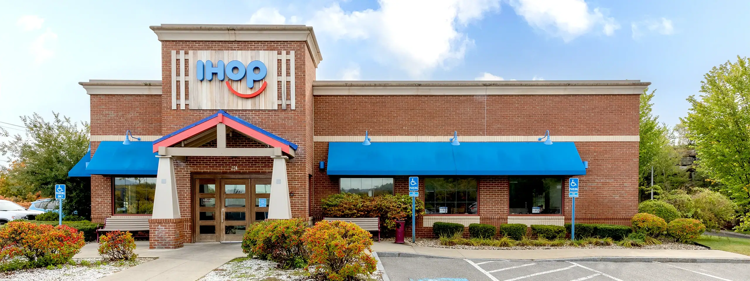 IHOP restaurant with blue awnings and a brick exterior in a shopping center.