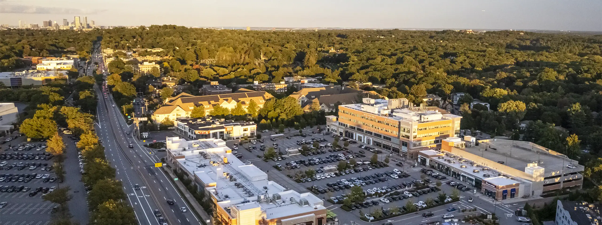 Aerial view of a commercial area with parking lots and surrounding greenery.